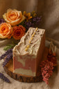 Handcrafted artisan soap Dragon Blood loaf by LUMÉA London placed on a wooden board with linen fabric, dried flowers, and botanical oils in a luxury boho styling.