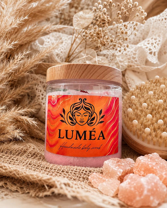 LUMÉA handmade body scrub in a clear jar with wooden lid, beautifully styled in a luxury boho spa setting with dried flowers, pampas grass and a natural body brush, showcasing premium handmade skincare.